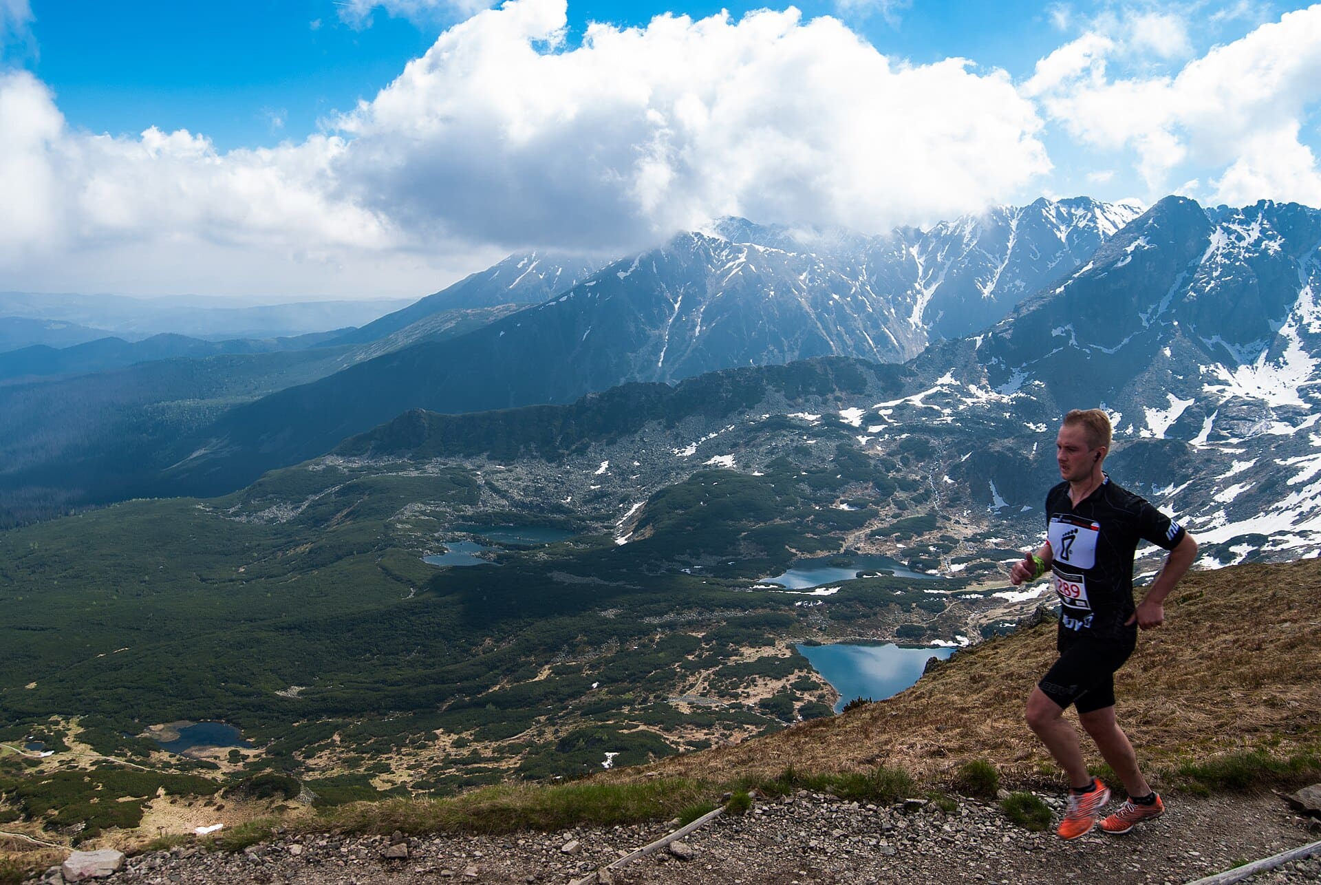 A lone runner climbing a mountain trail towards the summit